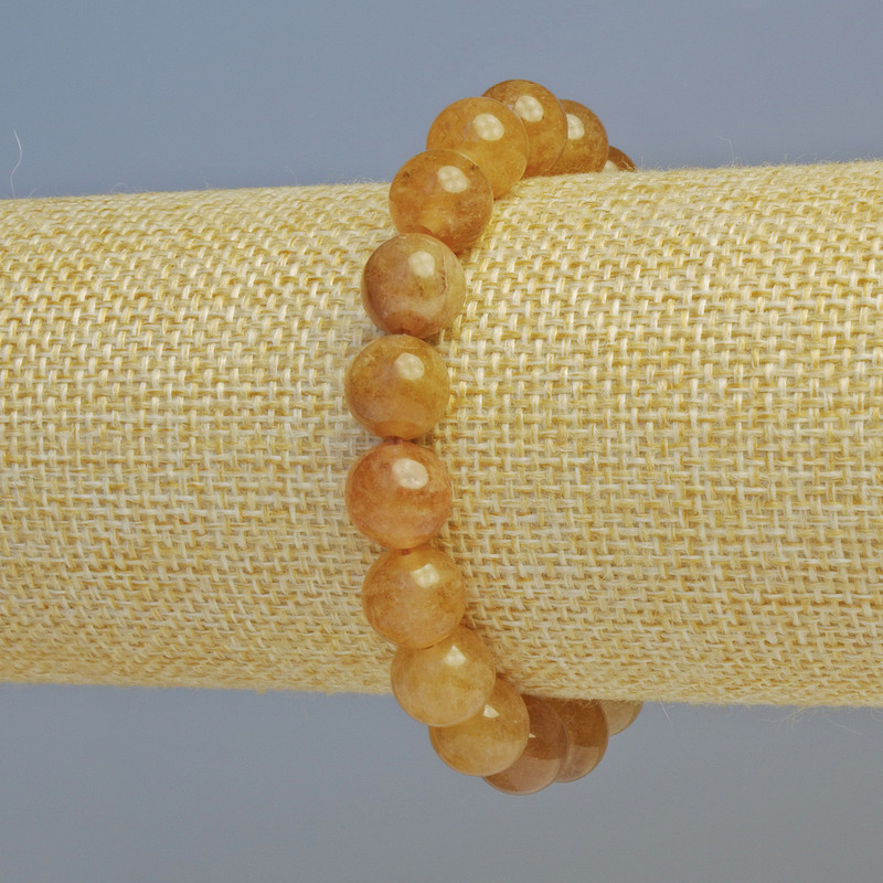 Náramek z kalcitu, hladké kuličky, průměr cca 10 mm ± (elastická šňůrka), délka 18 cm+