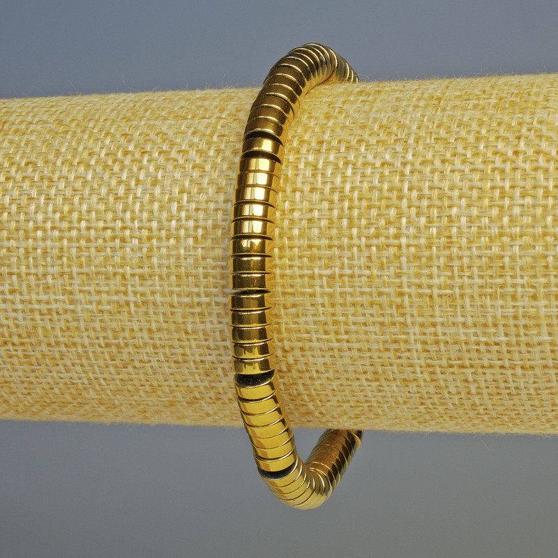 Náramek z hematitu tmavě zlaté barvy, rondelové korálky o průměru 6×2 mm, délka 18 cm, elastická šňůra