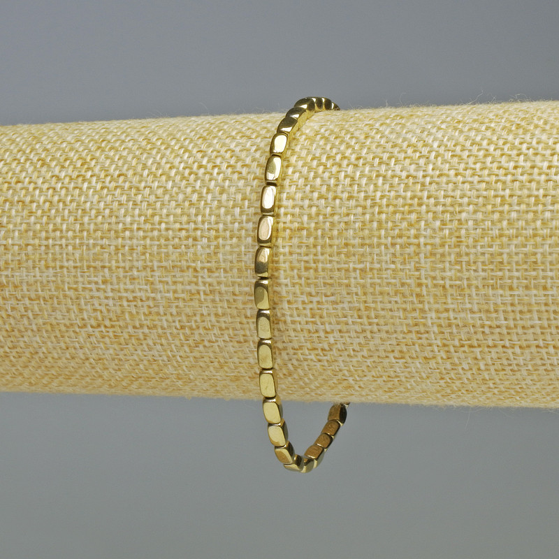 Náramek z hematitu, oválné obdélníkové korálky, zlatavý odstín, průměr 3×5 mm, délka 18 cm, elastická šňůrka