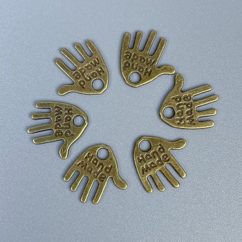 Přívěšek dlaň, ručně vyráběný, bronzová barva kovu, rozměry 12×11×1 mm ± otvor, průměr 1,5 mm ± balení 20 g (~50 ks)