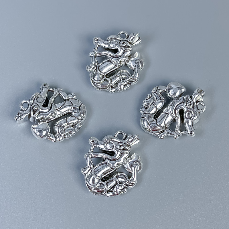 Přívěšek Drak, barva kovu stříbrná, rozměry 21×17×7 mm ± otvor 1,2 mm, balení 4 ks