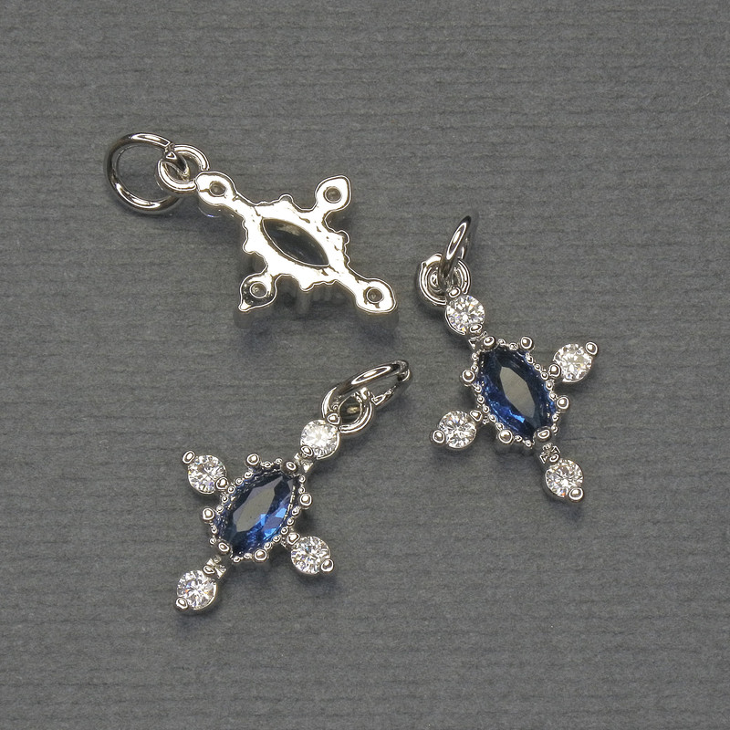 Přívěšek-kříž s bílými a modrými štrasami, stříbrný kov, rozměr 16×10 mm, délka cca 20 mm