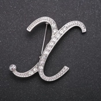 Brož iniciál písmeno „X“ s bílými štrasovými kameny, barva kovu šedá, 43×38 mm