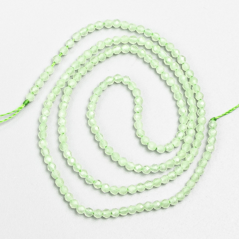 Drobné korálky ze syntetického spinelu, světle zelené, broušené kuličky, průměr cca 2 mm ±, navlečené na šňůrce, délka 37 cm