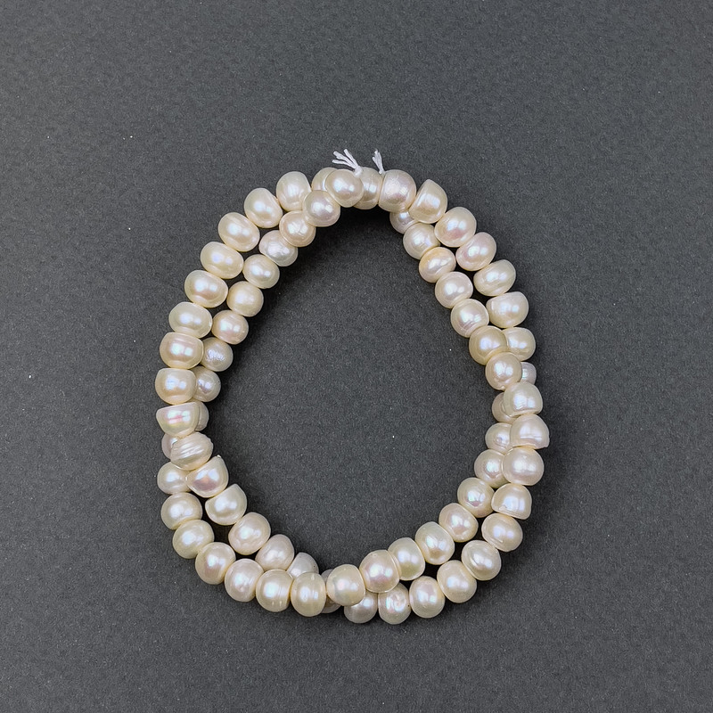 Říční oválné perly s odstínem „benzín“ na niti, průměr 7×5 mm ±, délka 39 cm