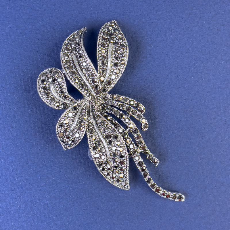 Brož se šedými štrasovými kamínky v tmavě stříbrném kovu, rozměry 70×35 mm +