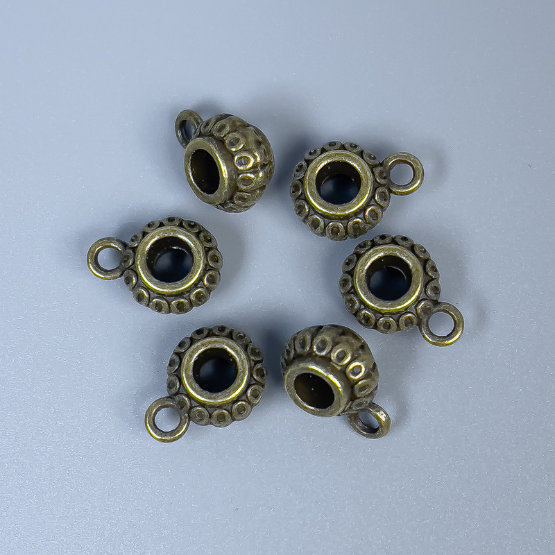 Poutko bronzové barvy pro šperky, rozměry 12×8×6 mm, otvory o průměru 4 mm +- a 2 mm +-; balení 20 g (~18 ks)