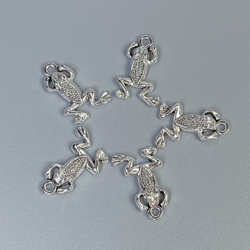 Přívěsek Žabka, barva kovu stříbrná, rozměry 20×13×3 mm ± otvor, průměr 1,5 mm ± balení 20 g (~18 ks)
