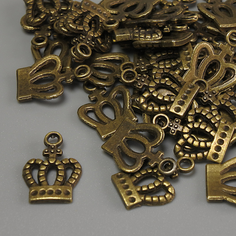 Přívěsek Koruna, bronzová barva, rozměry 15×10×1 mm ± otvor 2 mm ±, balení 20 g (~36 ks)