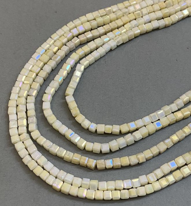 Korálky z Českého křišťálu žluté s benzínovým nástřikem na niti, broušené kubíky, průměr 4×4 mm, délka 38 cm