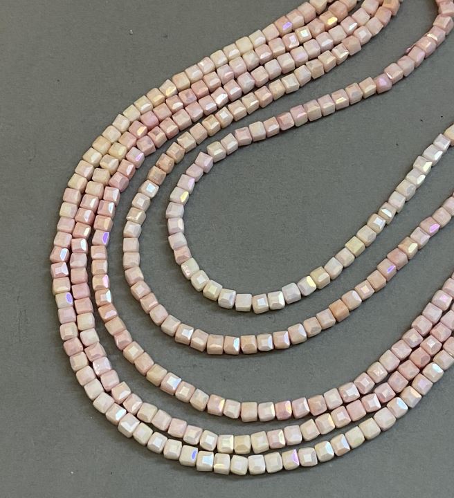 Korálky z českého křišťálu, růžové s povrchovou úpravou 'benzín' na niti, brusované kubíky 4×4 mm, délka 38 cm