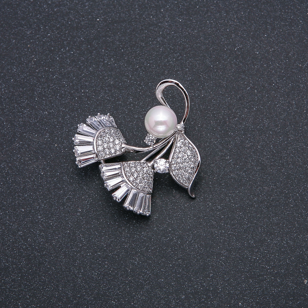 Brož Xuping s perlou Mallorca, rhodiovaná, s bílými kameny a štrasami, průměr perly cca 8 mm, rozměry 33 × 31 mm