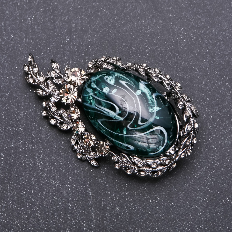 Brož se šedými štrasovými kamínky a smaragdovým cabochonem 64×38 mm, šedý kov