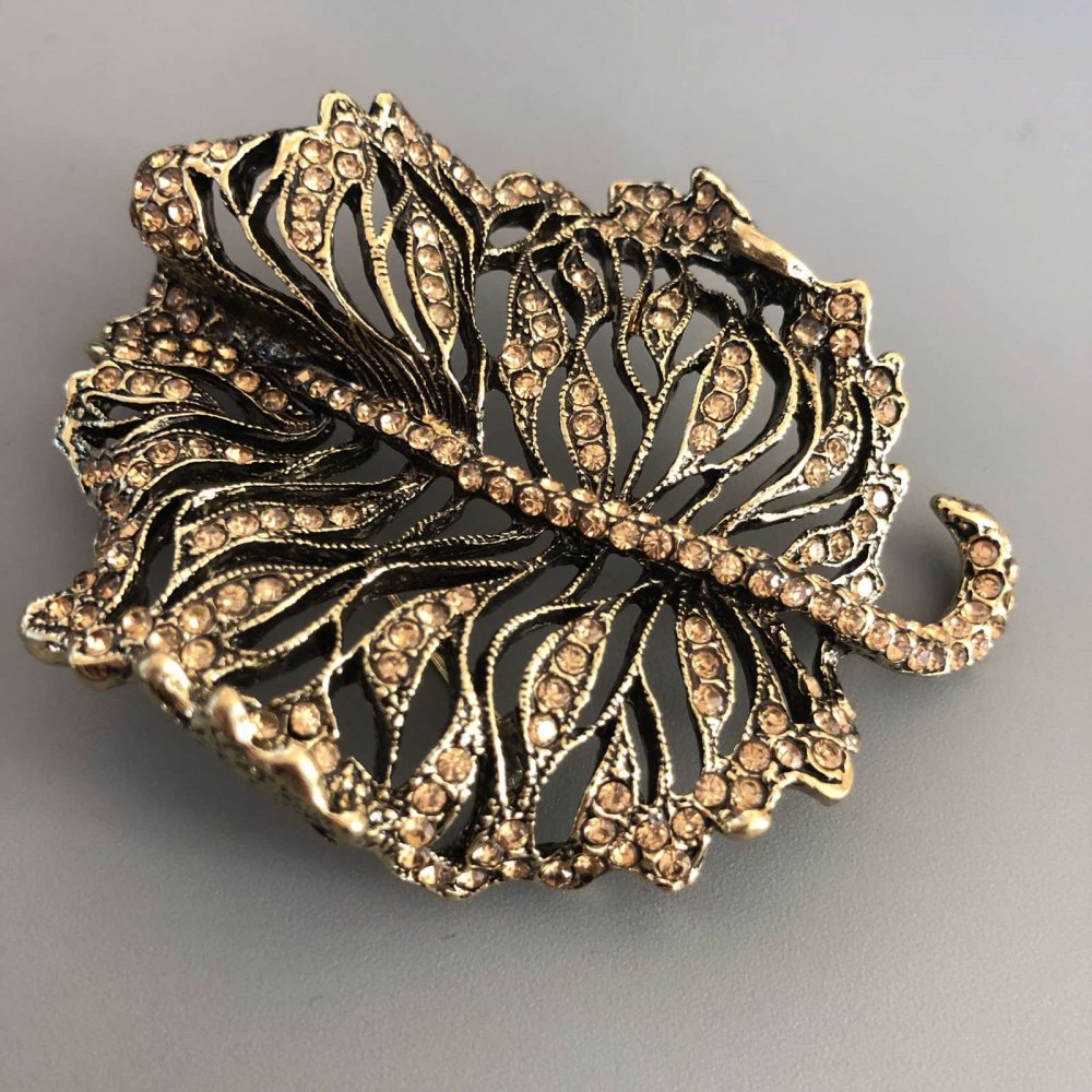 Brož ve tvaru listu se zlatými štrasovými kamínky, pozlacený kov 58 × 72 mm